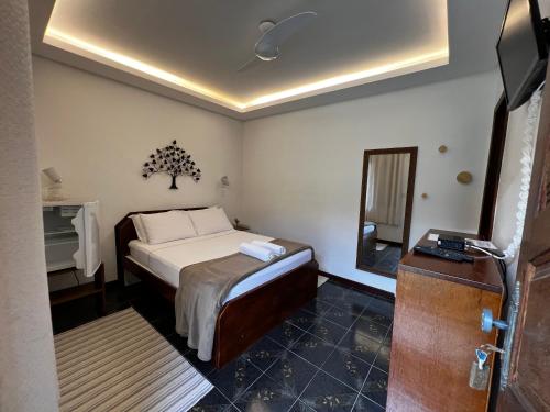 a small bedroom with a bed and a mirror at Porto Abraão Pousada in Abraão
