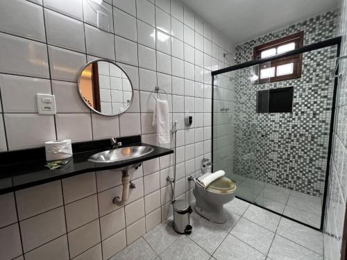 La salle de bains est pourvue d'un lavabo, de toilettes et d'un miroir. dans l'établissement Porto Abraão Pousada, à Abraão