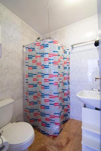 a bathroom with a toilet and a stack of paper towels at La Rukka Hostal Boutique in San Pedro de Atacama