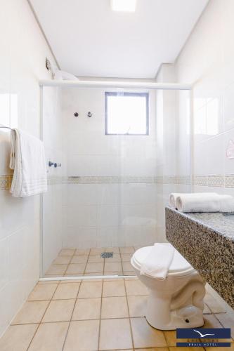 a white bathroom with a shower and a toilet at Gaivotas Praia Hotel in Florianópolis