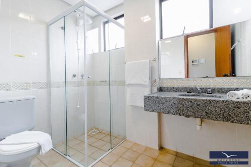 a bathroom with a shower and a toilet and a sink at Gaivotas Praia Hotel in Florianópolis