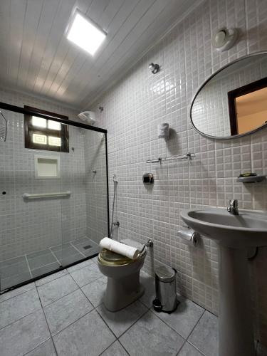 a bathroom with a shower and a toilet and a sink at Porto Abraão Pousada in Abraão