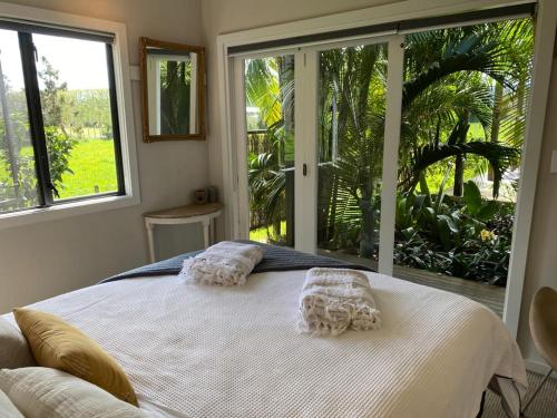 a bedroom with a white bed and a large window at The Perfect Dogbox in a tropical country setting! in Omaha