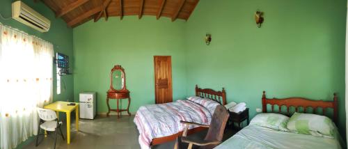 a bedroom with two beds and a mirror at cabañas playa guanico in Tonosí