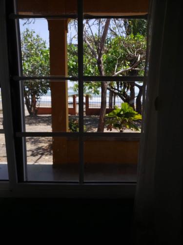 an open window with a view of a garden at cabañas playa guanico in Tonosí