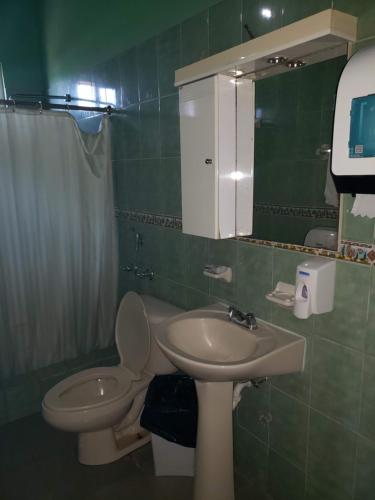 uma casa de banho com um lavatório, um WC e um espelho. em cabañas playa guanico em Tonosí