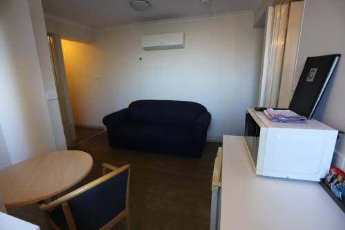 a room with a desk and a chair and a table at Citigate Motel Newcastle in Newcastle