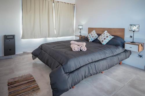 sypialnia z dużym łóżkiem z dwoma pluszakami w obiekcie Cabañas El Aby w mieście El Bolsón