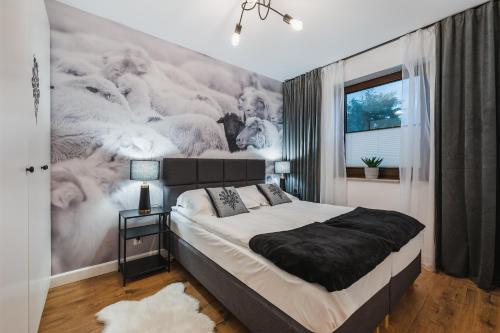 a bedroom with a bed with a wall mural of wolves at Czarna Owca in Jaworki