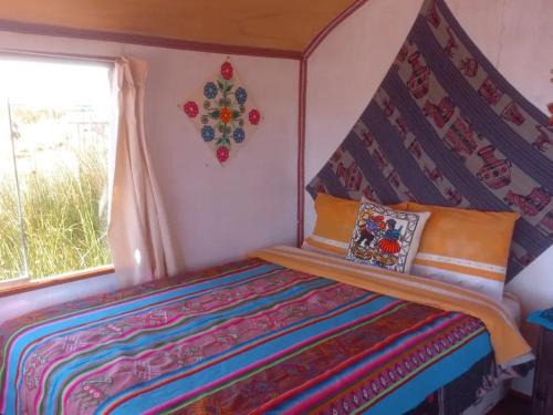 a small bedroom with a bed with a canopy at Uros Titicaca Khantaniwa Lodge in Puno