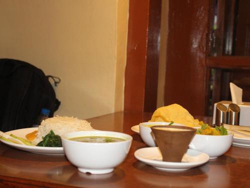 a table with bowls and plates of food on it at HOTEL RUPAKOT AND ROOFTOP RESTAURANT in Bhaktapur