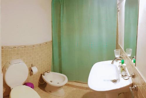 a bathroom with a white toilet and a sink at El Descanso in San Luis
