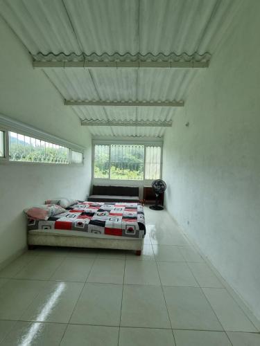 a bedroom with a bed in a white room at VILLETA, CASA CAMPESTRE CERCA DE PAYANDE in Villeta