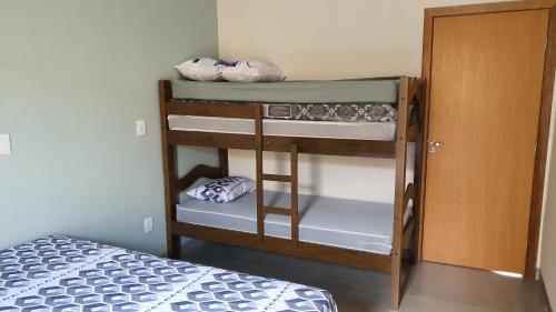 um quarto com um beliche e um quarto com uma cama em Beach House Olímpia - Casa Temporada em Olímpia