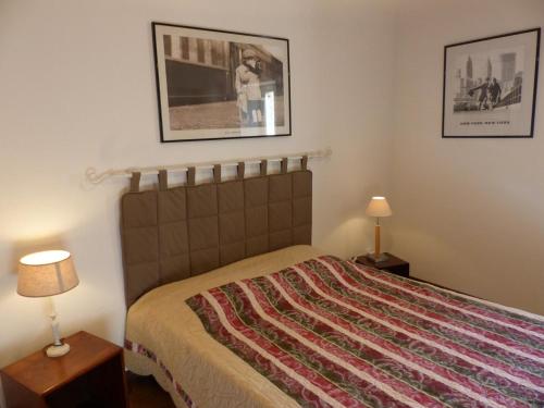 een slaapkamer met een bed met 2 lampen en 2 foto's bij Gîte Chirat-l'Église, 5 pièces, 10 personnes - FR-1-489-229 in Chirat-lʼÉglise