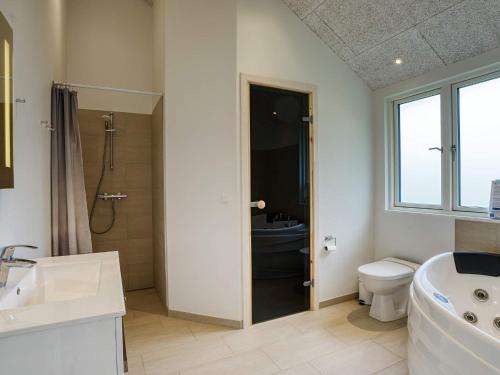 uma casa de banho com um WC, um lavatório e um chuveiro em Holiday home Dannemare XXXV em Dannemare