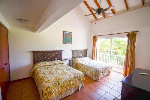a bedroom with two beds and a window at Costa Blanca Villas Lopez in Río Hato