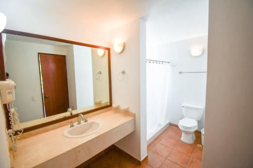 a bathroom with a sink and a toilet and a mirror at Costa Blanca Villas Lopez in Río Hato