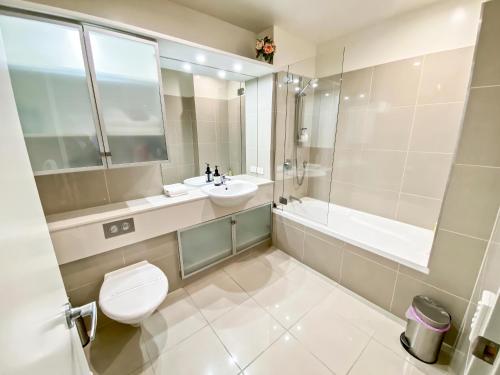 a bathroom with a toilet and a sink and a tub at Oxley's Superior Apartment in Picton