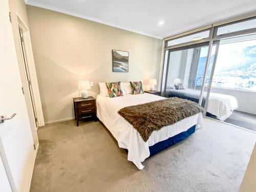 a bedroom with a bed and a large window at Oxley's Superior Apartment in Picton