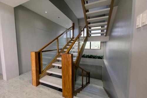 a staircase in a house with wood and glass at Madonna Hometel and Suites New Pandan in Panabo