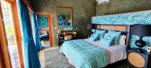 een slaapkamer met een bed met een blauw dekbed bij H616 Vintage Elegance with sea view in Kubutambahan