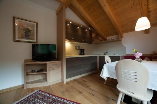 a kitchen and dining room with a table and a tv at Lüch da Mirió in La Valle