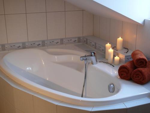 a bath tub with two candles and two towels at Domek Kozacki in Łukowe