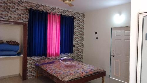 a bedroom with a bed and a window with curtains at Tendulkar Beach Resort in Diveagar