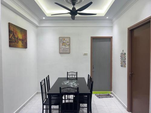 a dining room with a table and a ceiling fan at D’Alisya Homestay in Tawau