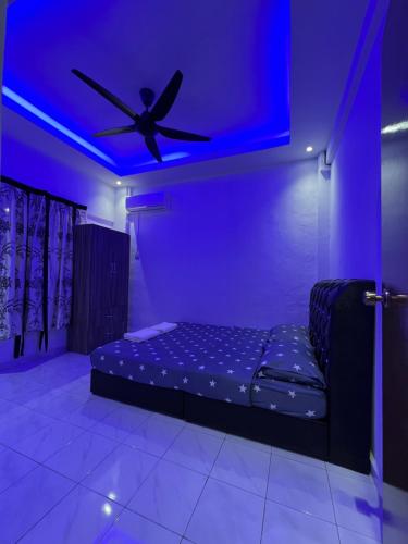 a room with a bed with a ceiling fan at D’Alisya Homestay in Tawau