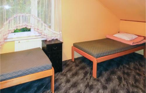 ルビャトボにある4 Bedroom Gorgeous Home In Choczewoのベッド2台と窓が備わる小さな客室です。