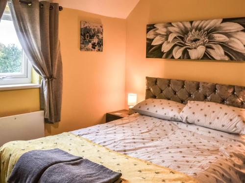 um quarto com uma cama com uma fotografia de flores na parede em The Beehive em Miningsby