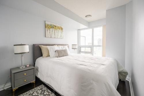 Un dormitorio blanco con una cama grande y una ventana en GLOBALSTAY 1 Bedroom & Den Condo in the Heart of Downtown Toronto, en Toronto