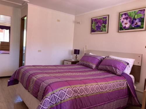 Un dormitorio con una cama púrpura con mantas y almohadas púrpuras. en Loft cerca de playa, en Viña del Mar