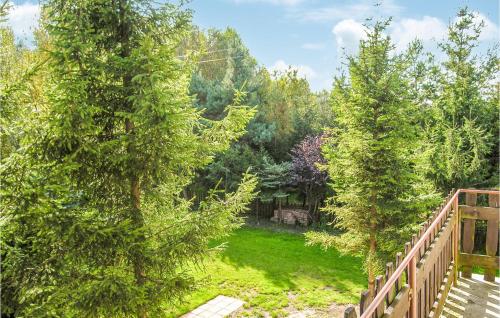 a garden with trees and a wooden bridge at Holiday Home Choczewo Ulwschodnia in Lubiatowo