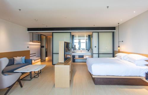 una camera con un grande letto bianco e un divano di Fairfield by Marriott Liaocheng Dongchangfu a Liaocheng