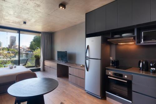 eine Küche mit einem Kühlschrank und einem Tisch in der Unterkunft Live Soho Boutique & Apartments Palermo Soho in Buenos Aires