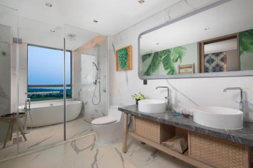 ein Badezimmer mit zwei Waschbecken und einem großen Spiegel in der Unterkunft Holiday Inn Resort Qionghai Guantang, an IHG Hotel in Qionghai
