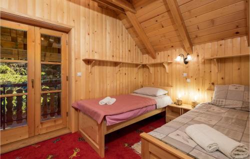 a bedroom with two beds in a wooden cabin at Pet Friendly Home In Mrkopalj With Kitchen in Mrkopalj