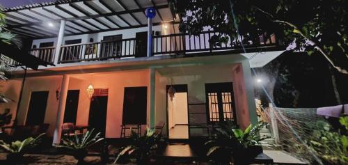 a house at night with a balcony on top at Sundance Surf Coconut Point in Weligama