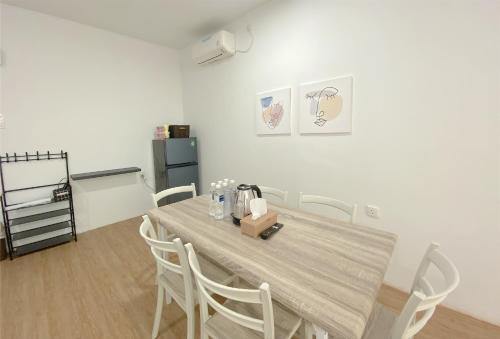 ナゴヤにあるCN Homestay B1 Floor 2 at Nagoya Hill Mallの木製のテーブルと椅子のあるダイニングルーム