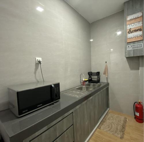 a kitchen with a counter with a microwave and a sink at CN Homestay B2 Floor 2 at Nagoya Hill Mall in Nagoya