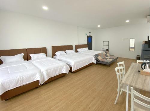 ナゴヤにあるCN Homestay B3 Floor 2 at Nagoya Hill Mallのベッド3台とテーブルがあるホテルの部屋