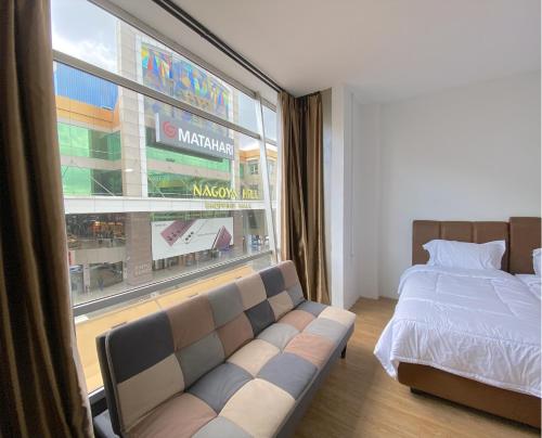 ナゴヤにあるCN Homestay B1 Floor 2 at Nagoya Hill Mallのベッドルーム(ソファ、大きな窓付)