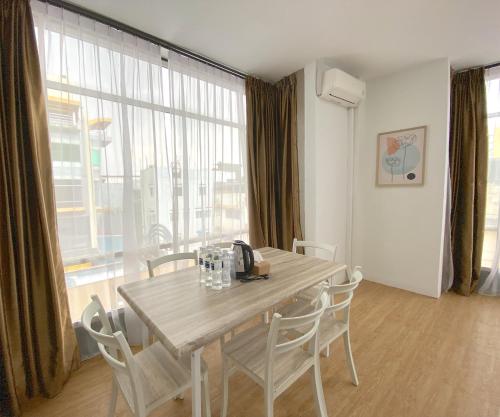 ナゴヤにあるCN Homestay B3 Floor 2 at Nagoya Hill Mallのテーブルと椅子と大きな窓のあるダイニングルーム