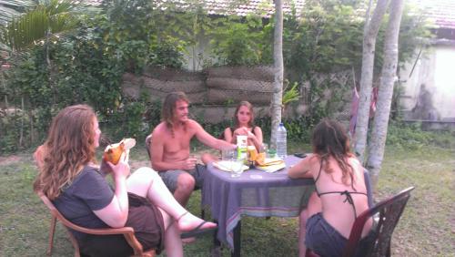 a group of people sitting around a table at Sundance Surf Coconut Point in Weligama