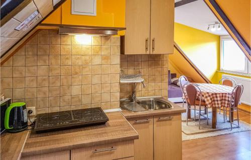 a kitchen with a sink and a table with chairs at Beautiful Apartment In Wladyslawowo With 2 Bedrooms And Wifi in Władysławowo