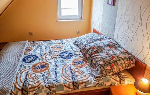 a small bedroom with a bed with a colorful bedspread at Beautiful Apartment In Wladyslawowo With 2 Bedrooms And Wifi in Władysławowo