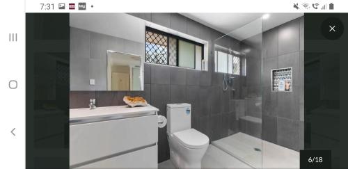 a bathroom with a toilet and a sink and a shower at Jen's Getaway in Glass House Mountains